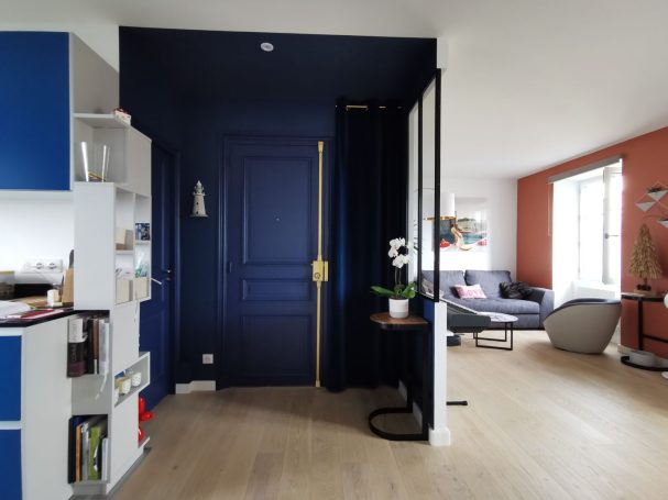 Appartement rénové entrée bleu marine avec verrière sur séjour terracotta et cuisine ouverte